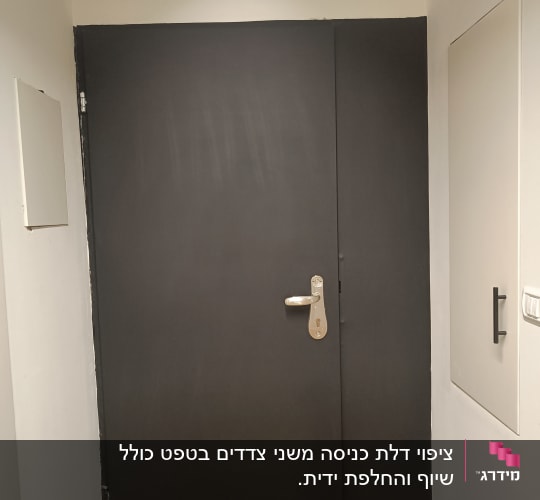 דלת שחורה עם ידית כסופה על רקע קיר לבן